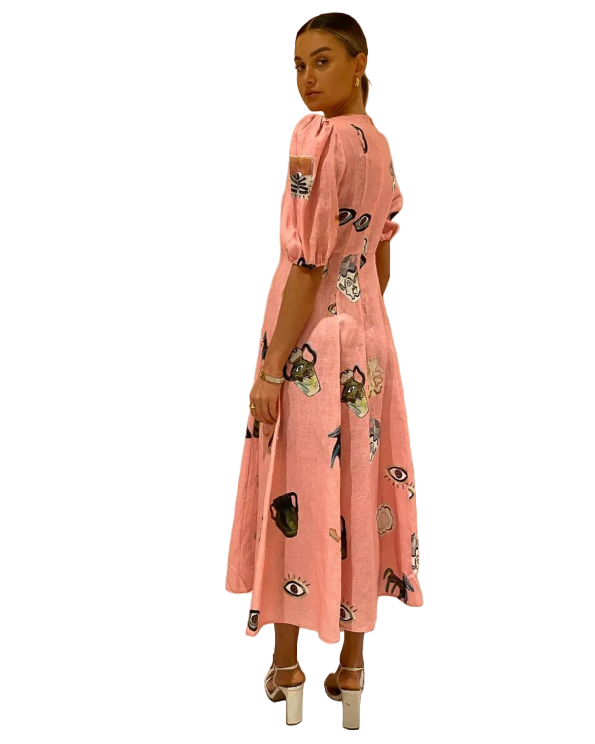 Woman wearing a pink dress with black patterns against a beige background