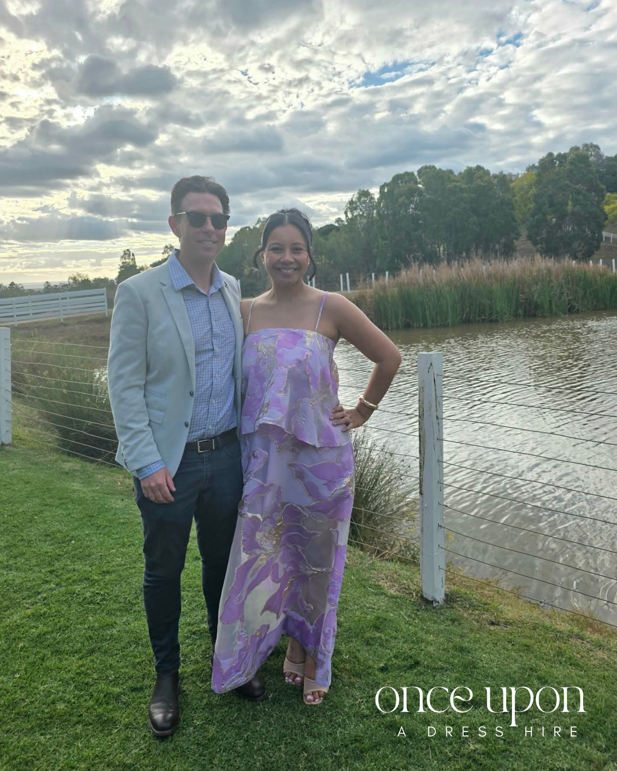Elliatt Elysia Tiered Gown in purple floral, lifestyle view with a partner by a lake