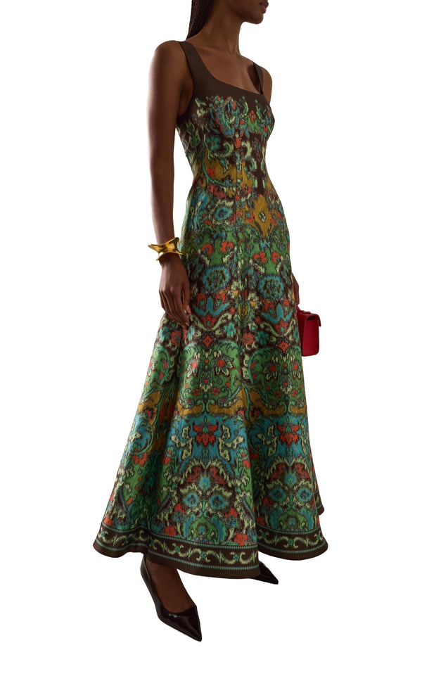 Alemais Charlotte Gown in green watercolour print, front view with red clutch
